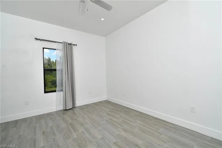 Spare room featuring wood finish floors and a ceiling fan