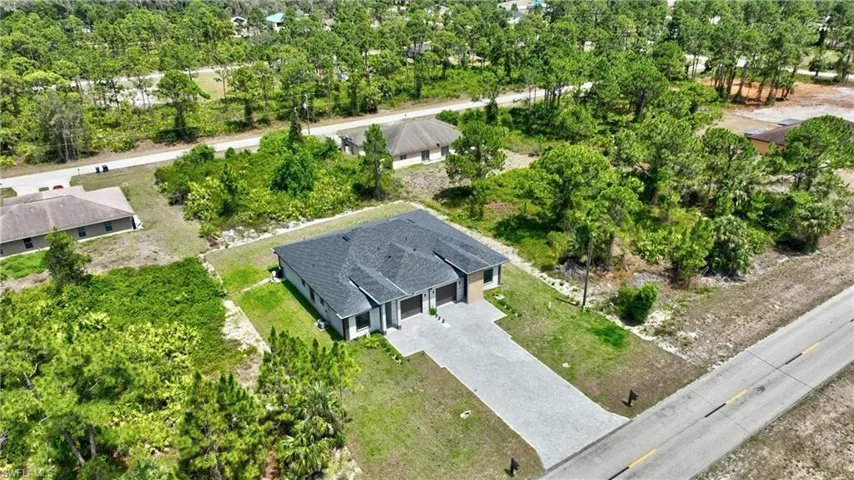 View of subject property featuring a tree filled landscape