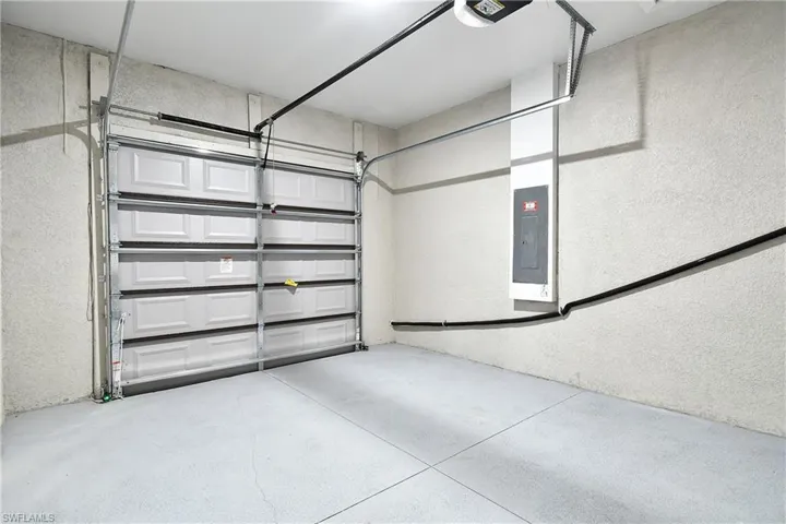 Garage featuring electric panel and a garage door opener