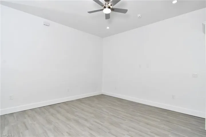 Spare room with light wood-style floors, a ceiling fan, and recessed lighting
