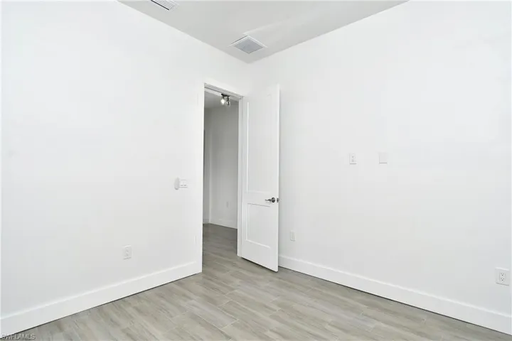 Spare room featuring baseboards and light wood finished floors