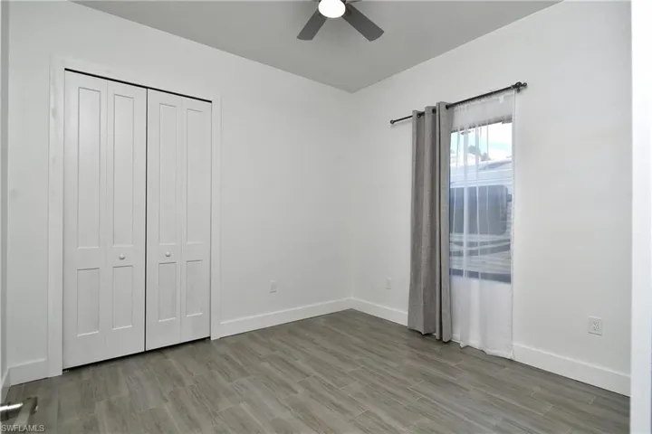 Unfurnished bedroom with ceiling fan, light wood-style flooring, and a closet
