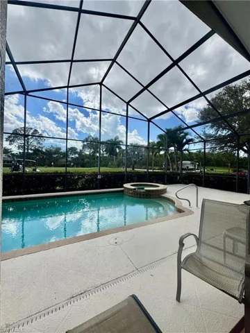 Integrated pool / hot tub featuring a sunroom, glass enclosure, and a patio area