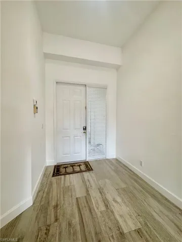 Foyer entrance with light wood finished floors and baseboards