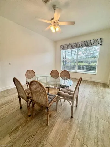 Dining area with a textured ceiling, ceiling fan, and light wood finished floors
