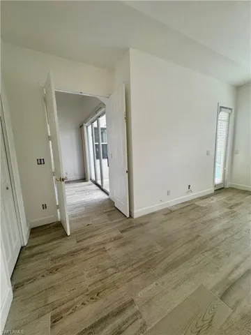 Spare room featuring light wood-style floors and arched walkways