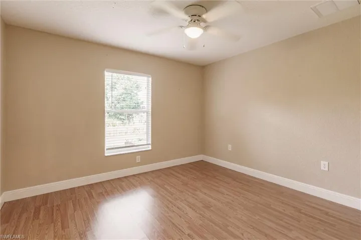 Empty room with ceiling fan and light wood-type flooring