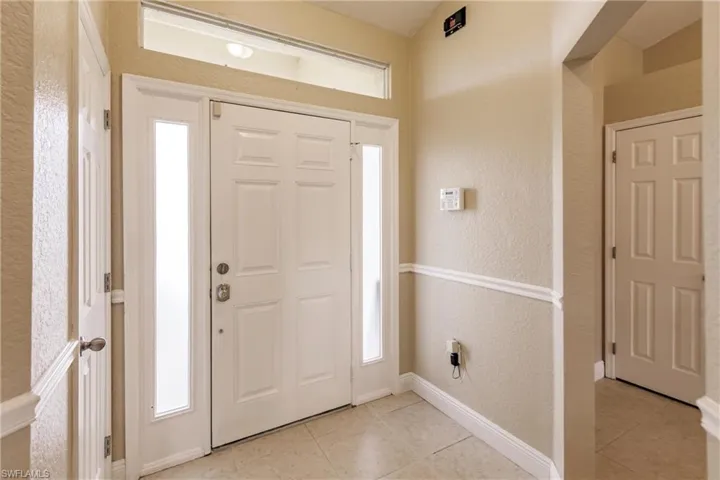 Entrance foyer with a healthy amount of sunlight and light tile patterned floors