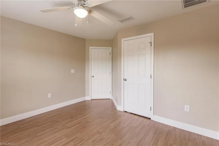 Unfurnished bedroom featuring wood-type flooring and ceiling fan