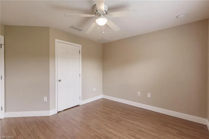 Spare room with ceiling fan and wood-type flooring