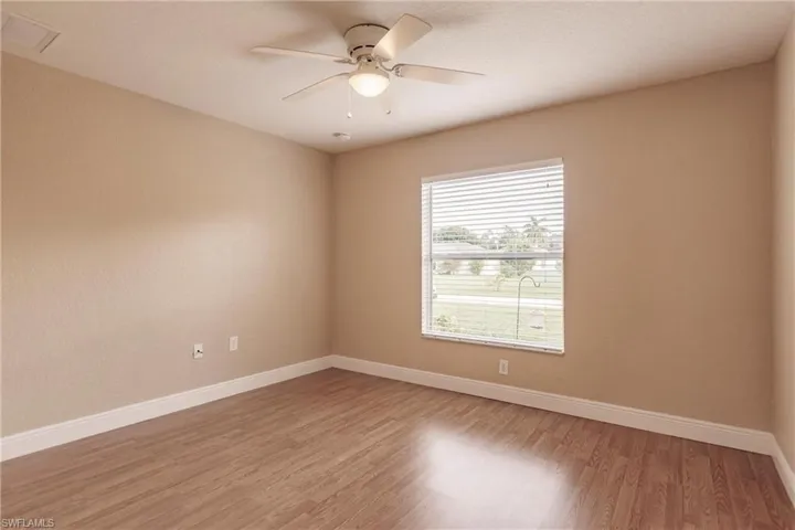 Empty room with hardwood / wood-style flooring and ceiling fan
