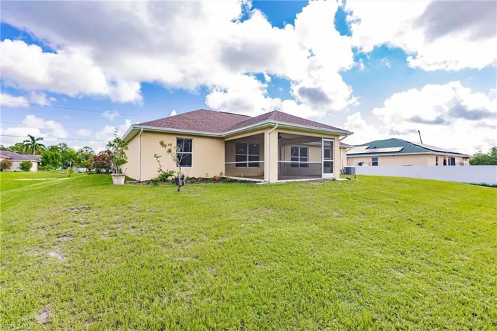 Rear view of property with a yard and a sunroom