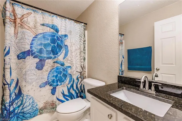 Bathroom featuring toilet, vanity, and a textured ceiling