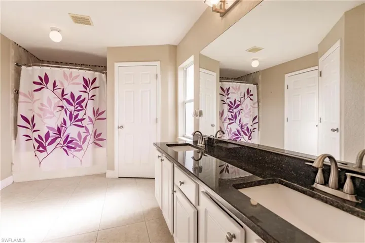 Bathroom featuring tile patterned floors and double sink vanity