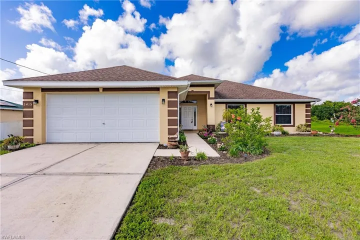 Ranch-style home featuring a garage and a front yard