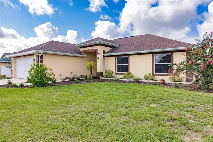 View of front of house with a garage and a front yard