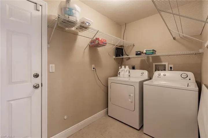 Laundry room featuring light tile patterned flooring and separate washer and dryer