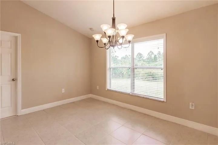 Unfurnished room featuring an inviting chandelier and light tile patterned floors