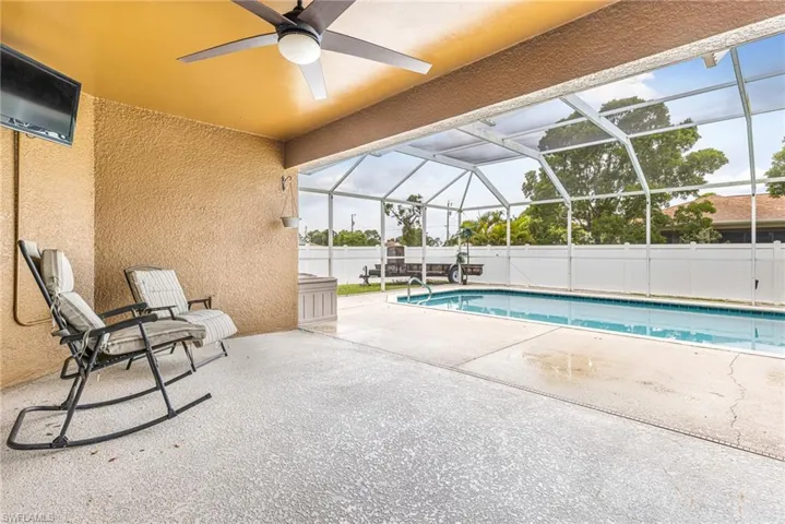 View of swimming pool featuring a patio, a ceiling fan, fence, and a fenced in pool
