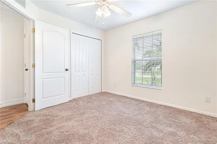 Unfurnished bedroom with baseboards, ceiling fan, a closet, and visible vents