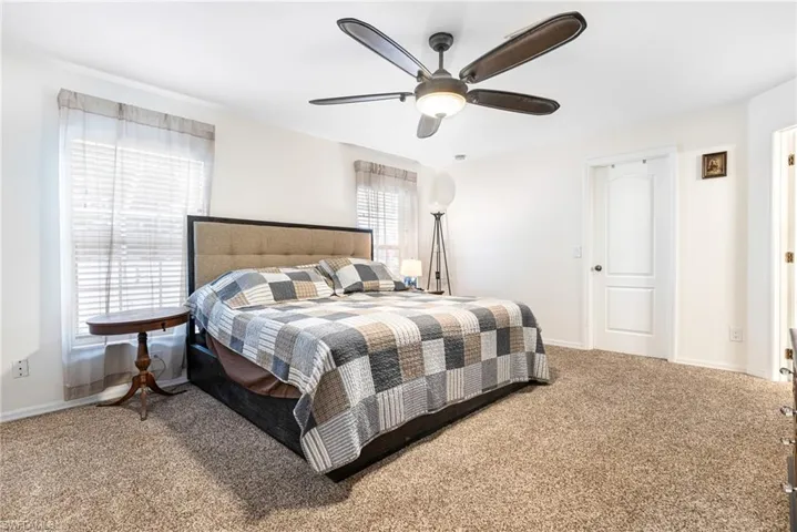 Bedroom with baseboards, ceiling fan, and carpet flooring