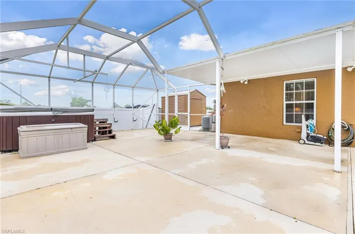 View of patio / Lanai featuring a hot tub, an outbuilding, a shed