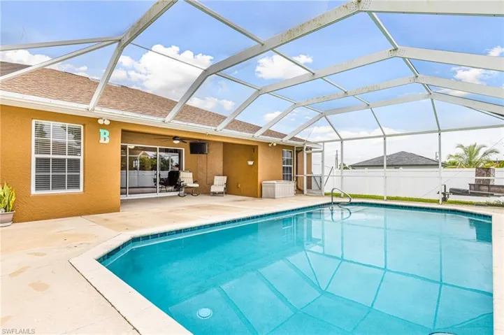 View of swimming pool with a fenced in pool, a ceiling fan, a patio area, and a lanai