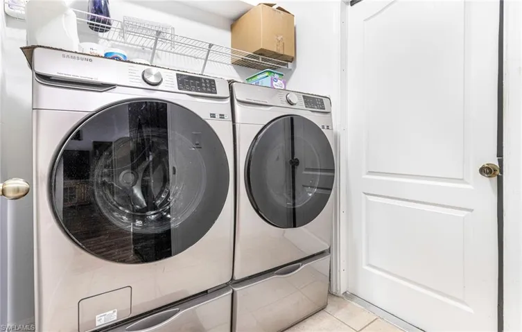 Laundry room featuring laundry area, light tile patterned floors, and washing machine and dryer