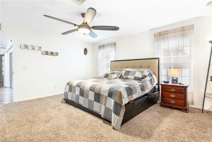 Carpeted bedroom featuring baseboards and a ceiling fan
