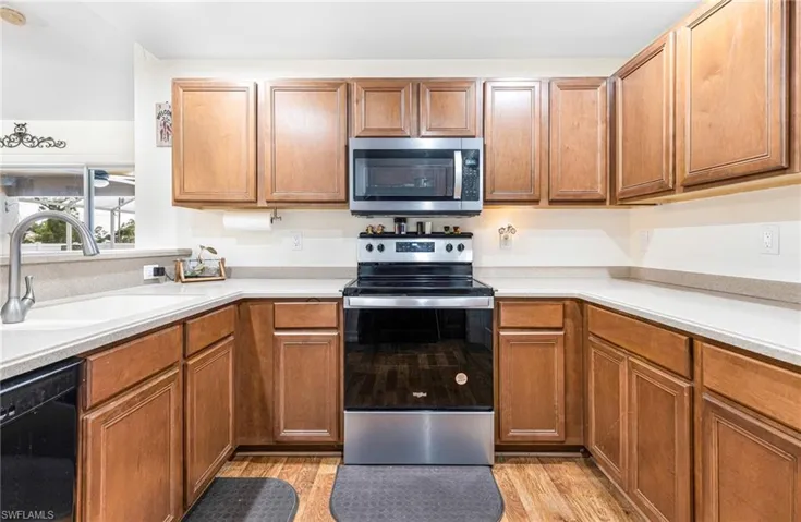Kitchen featuring a sink, light countertops, stainless steel appliances, and light wood-style flooring