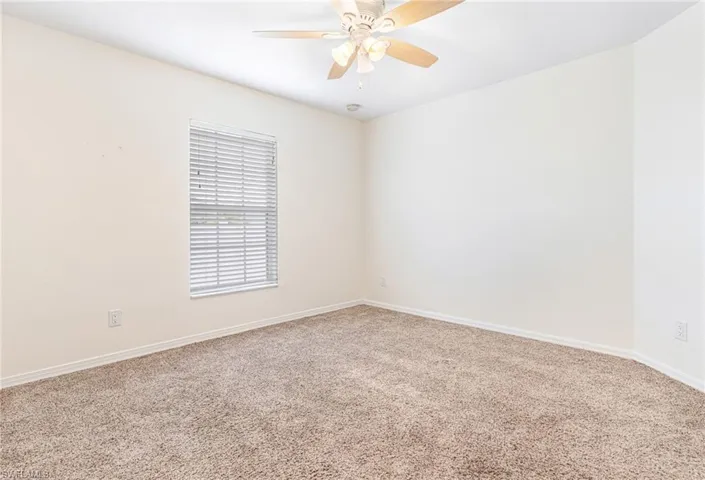 Empty room featuring baseboards, carpet flooring, and ceiling fan