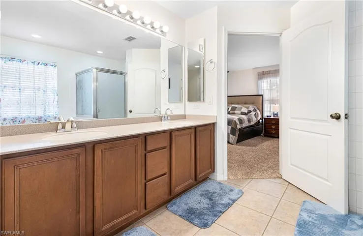 Full bathroom with visible vents, a sink, tile patterned flooring, and a stall shower