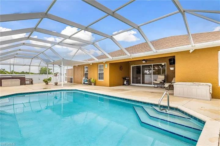 Outdoor pool with a patio, ceiling fan, a lanai, and a spa