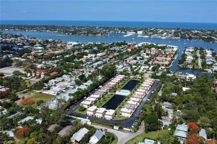 Aerial view of property and surrounding area featuring a large body of water and nearby suburban area