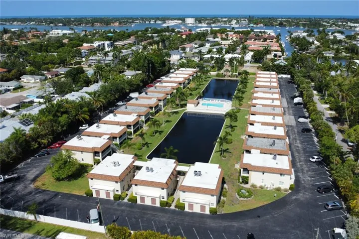 Aerial view of property and surrounding area with nearby suburban area and a nearby body of water