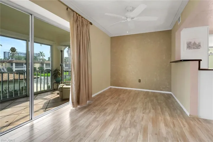 Unfurnished room with wood finished floors, ceiling fan, and crown molding