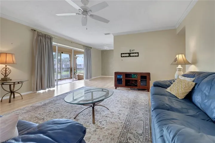 Living room featuring ornamental molding, wood finished floors, and ceiling fan