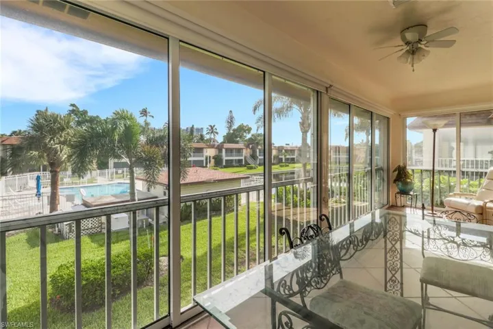 Sunroom / solarium featuring tile patterned floors, a residential view, and a water view