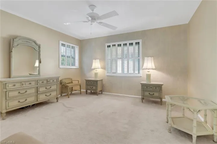 Sitting room featuring ceiling fan, light carpet, and crown molding