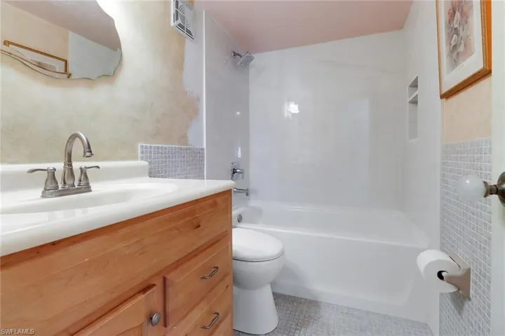 Full bath featuring vanity, shower / washtub combination, and tile patterned flooring