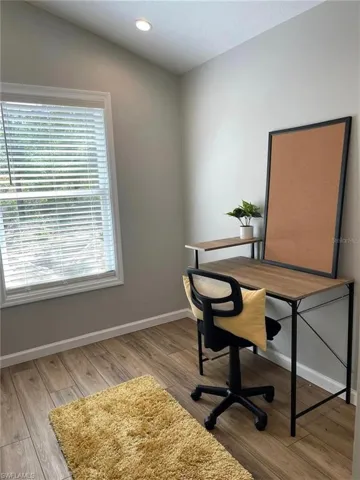 Home office featuring light wood-type flooring and vaulted ceiling