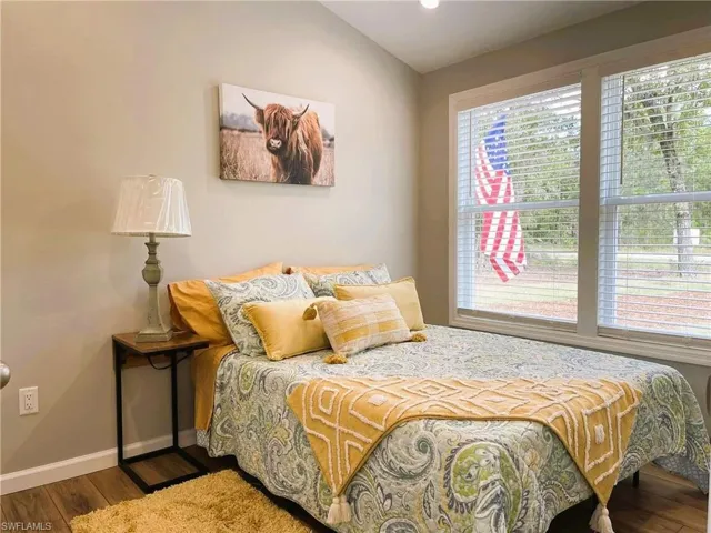 Bedroom with lofted ceiling and hardwood / wood-style floors