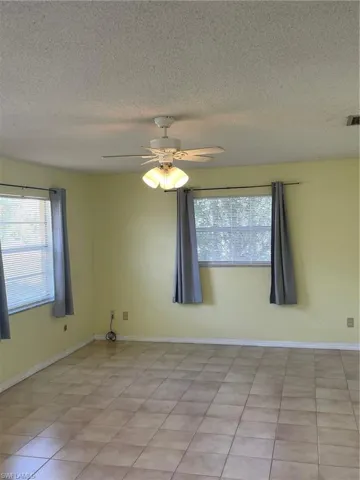 Unfurnished room with ceiling fan and a textured ceiling