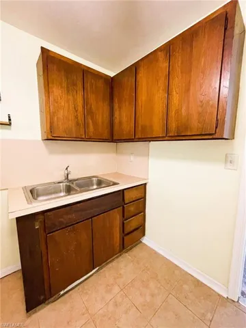 Kitchen with light countertops, light tile patterned flooring, and wood finish cabinets
