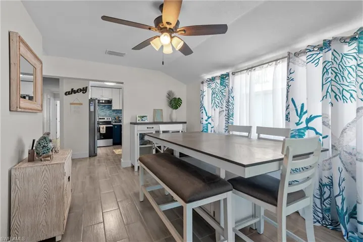 Dining space featuring ceiling fan, vaulted ceiling, and light wood-type flooring