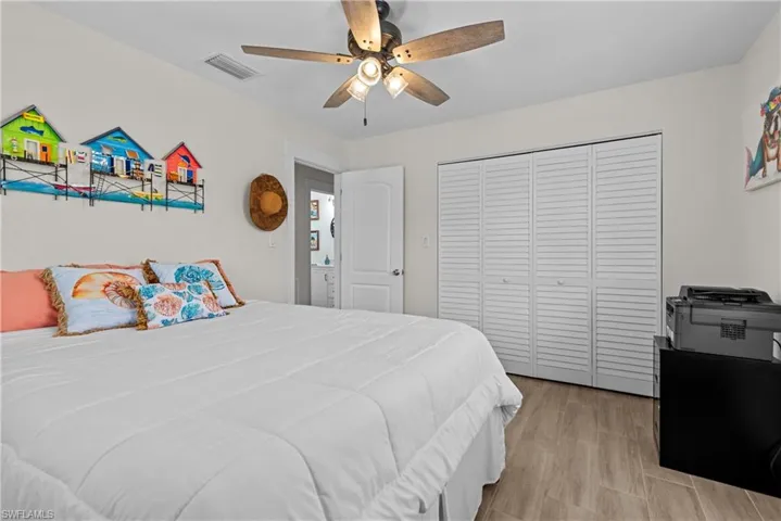 Bedroom with a closet, ceiling fan, and light hardwood / wood-style flooring