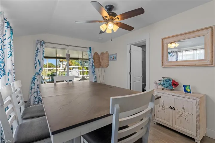 Dining space with ceiling fan, light wood-type flooring, and lofted ceiling