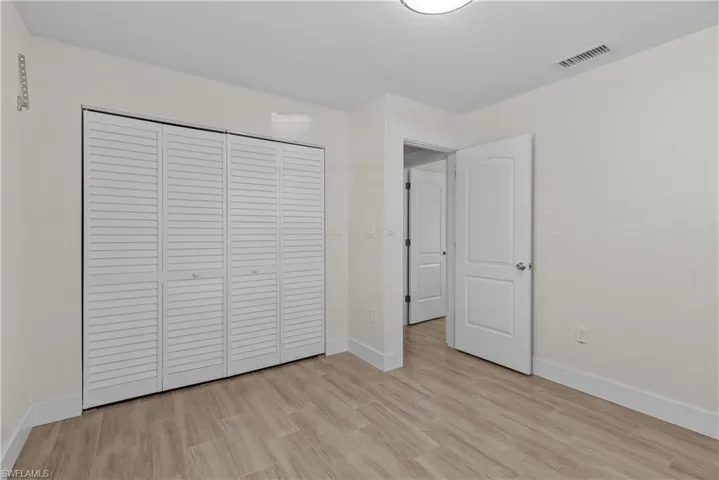 Unfurnished bedroom with light hardwood / wood-style floors and a closet