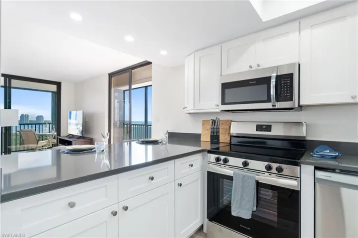 Kitchen with appliances with stainless steel finishes, white cabinetry, recessed lighting, and healthy amount of natural light
