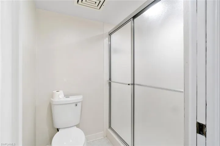 Bathroom with a shower stall and toilet